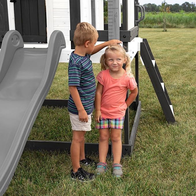 Backyard Discovery Sweetwater Heights White Elevated Cedar Wooden Kids Playhouse with Wave Slide, Play Kitchen, Step Ladder, Half Door, Wrap-Around Deck, Windows, Bell, Growth Chart for Outdoor Play